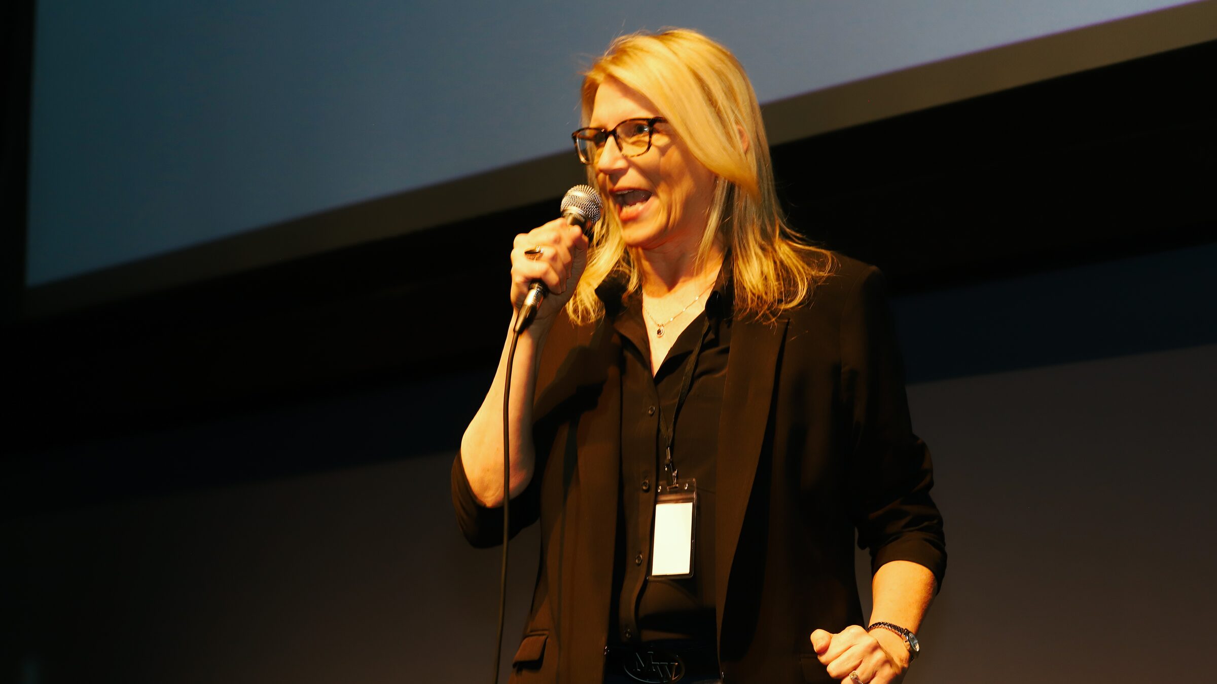 A comedian performing with a microphone on stage during the 2026 festival
